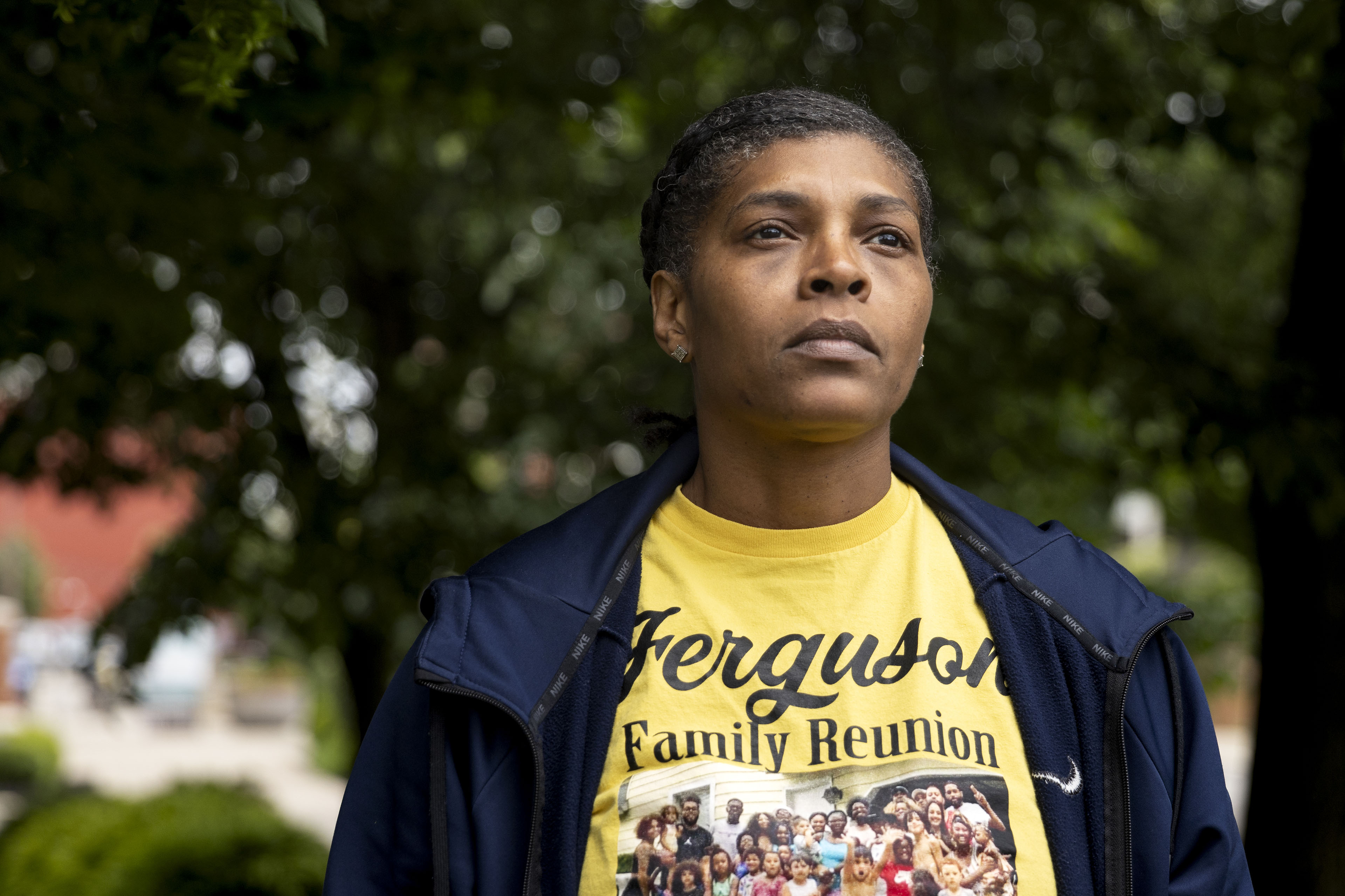 A portrait of a woman wearing a shirt that has a picture of her family at a reunion celebration.
